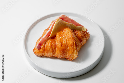 Ham and Cheese croissant sandwich on white plate food concept.