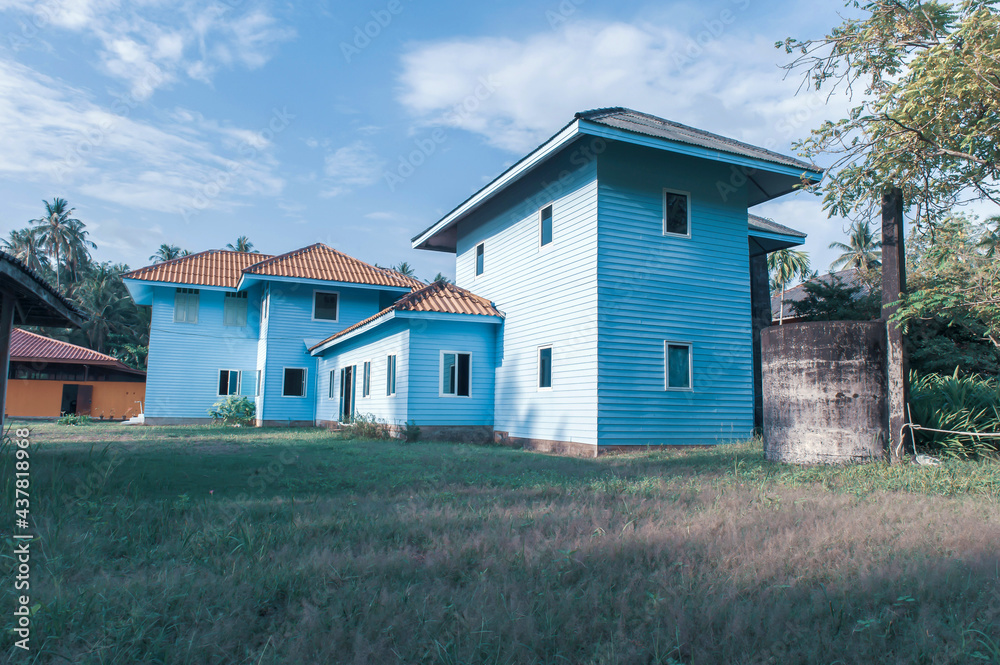 Obraz premium Picturesque exterior of an old blue wooden house.