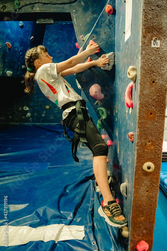 young child girl on climbing wall, bouldering