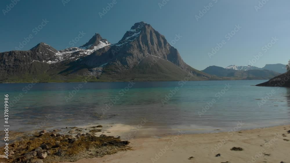 Aerial drone pan right of breathtaking sand beach landscape with Blokktinden mountain at Helgeland coast in northern Norway Aerial drone pan right of breathtaking sand beach landscape with Blokktinden mountain at Helgeland coast in northern Norway