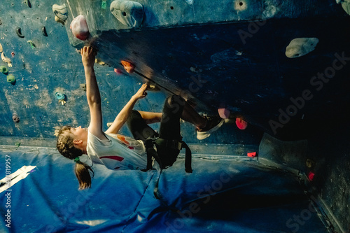 young child girl on climbing wall, bouldering