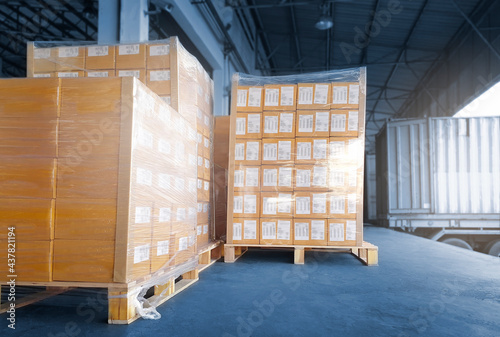 Stacked of Package Boxes Load into Cargo Container. Truck Parked Loading at Dock Warehouse. Delivery Service. Shipping Warehouse Logistics. Cargo Shipment. Freight Truck Transportation.	