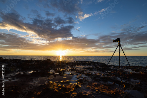 Silhouette of canon camera and tripod taking pictures of sunset at Cape Peron National Park, Western Australia