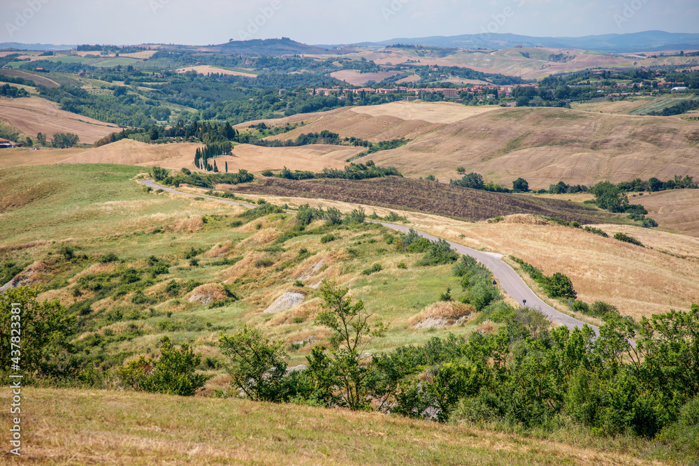 Panorama of view green and yellow fields of Asciano area at harvest time, Siena Province, Tuscany, Italy