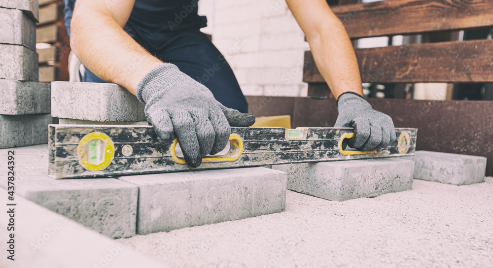Worker lining paving slabs path Worker lining paving slabs path
