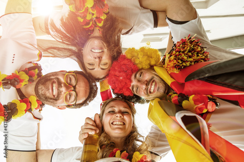 Gruppe glücklicher Fußballfans aus Deutschland feiern gemeinsam einen Meisterschaft Sieg. photo