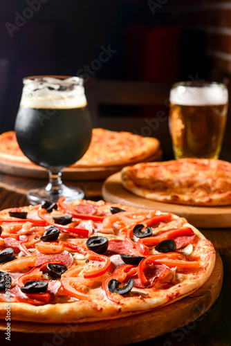 Fresh craft beer and pizza with vegetables and meat. Party concept, different kinds of pizza with delicious craft beer