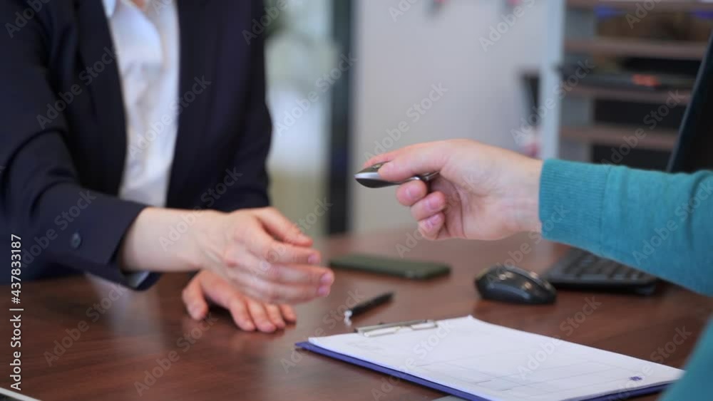 Buy car, sales manager give key to client close up in service office Spbas. Agent and consumer sit Buy car, sales manager give key to client close up in service office Spbas. Agent and consumer sit