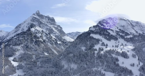 Wallpaper Mural Bare pine trees at the side of giant mountains with peaks partly covered with white snow and into the low hanging clouds on a cold sunny winter day. Wide Drone dolly shot Torontodigital.ca
