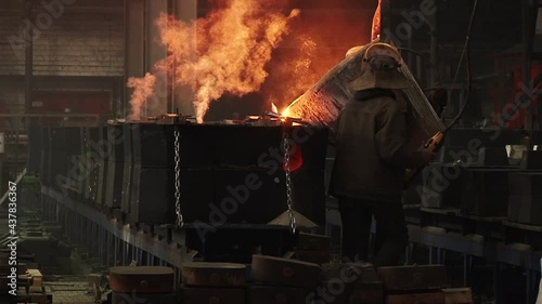 metal smelting plant. Workers remelt metal. high temperature. Cup work.  photo