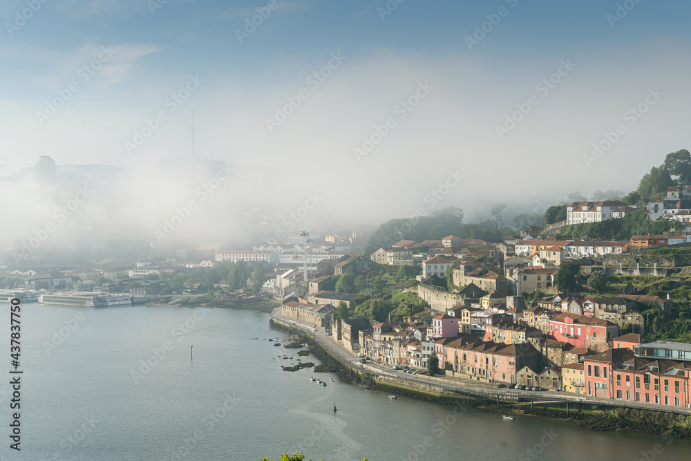 Summer morning view above beautiful Porto city from Portugal. Foggy cityscape in the start of a sunny day. Landmarks from Europe. A place to travel.