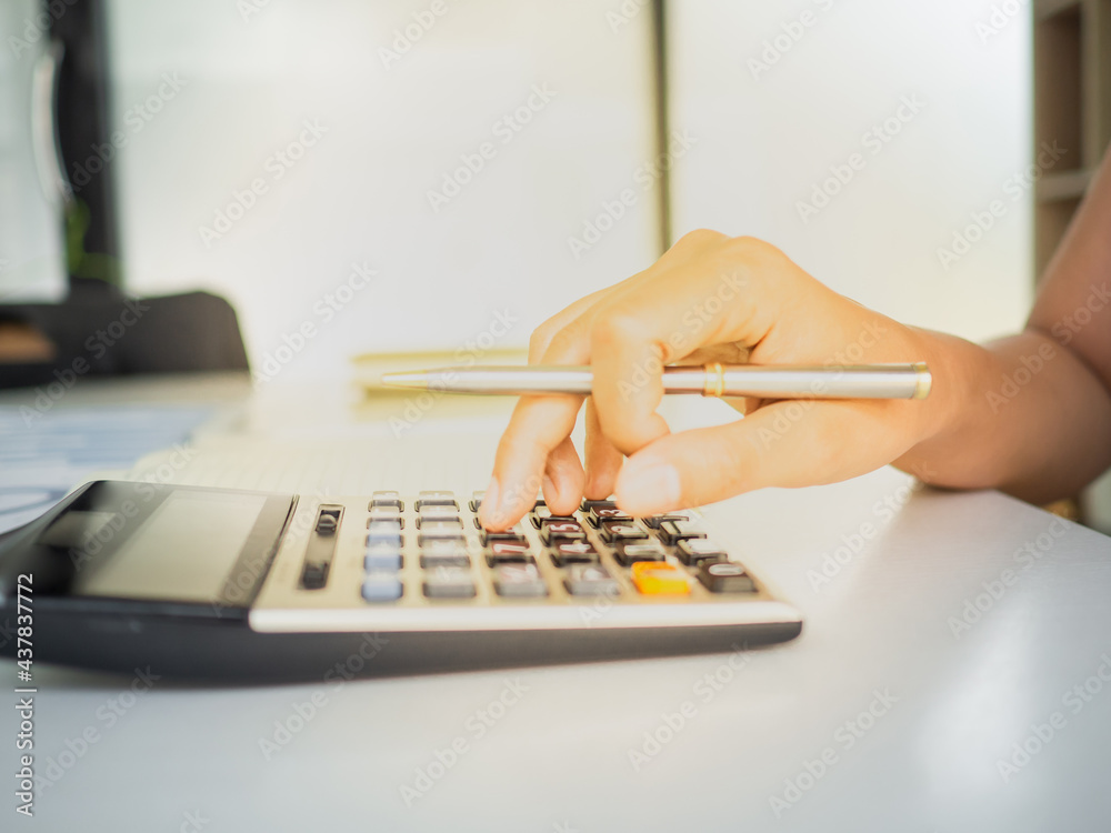 isolate hand of an accounting using a calculator calculate financial balance of a business. office desktop with hands working on financial and tax. with copy space.