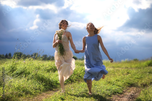 Young girls are walking in the field © alexkich