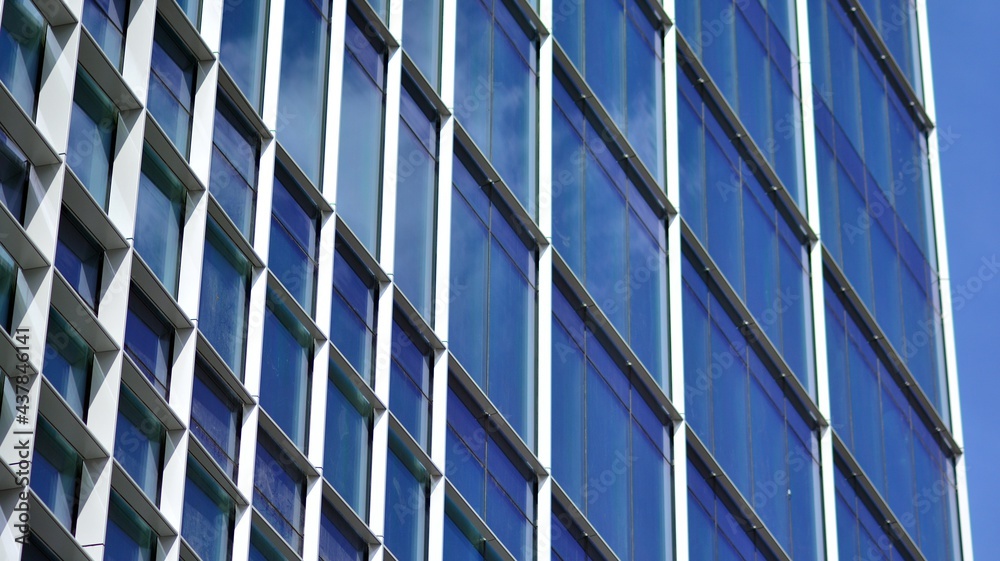 Modern architecture with sun ray. Glass and steel facade on a bright sunny day with sunbeams on the blue sky. Economy, finances, business activity concept. Modern architecture with sun ray. Glass and steel facade on a bright sunny day with sunbeams on the blue sky. Economy, finances, business activity concept.