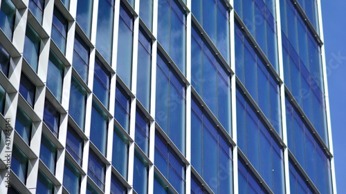 Modern architecture with sun ray. Glass and steel facade on a bright sunny day with sunbeams on the blue sky. Economy, finances, business activity concept.