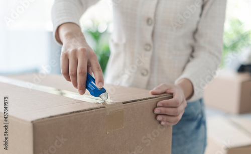 Woman opening a box using a cutter