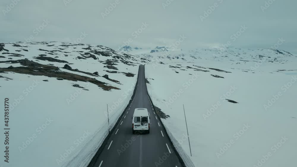 Drone aerial shot, camera follows cute vintage camping van driving ...