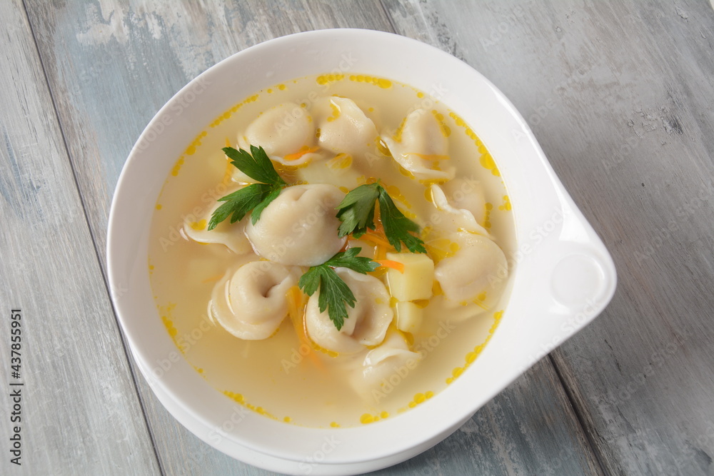 Soup with pelmeni (russian dumplings). Soup with meat dumplings, potatoes and other vegetables