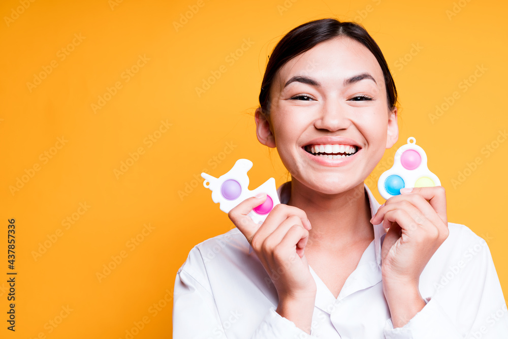 Portrait of happy asian girl holding simple dimple kids toys and smiling broadly Portrait of happy asian girl holding simple dimple kids toys and smiling broadly