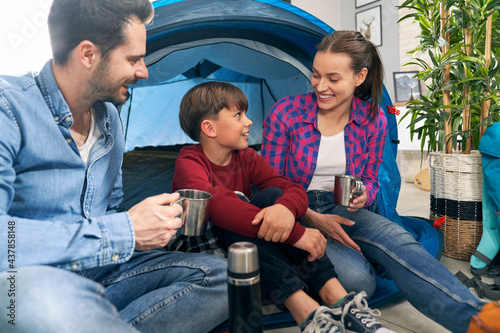 Family sitting in the tent while camping at home