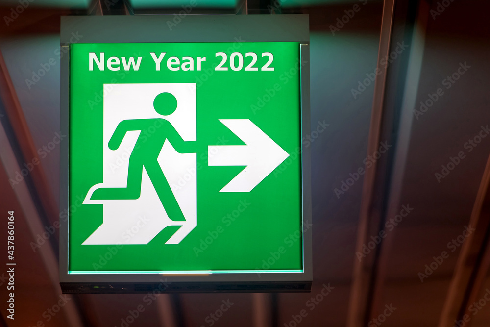 The emergency exit sign shows the direction of escape for happy New Year. The board pointing way to New Year 2022. The emergency exit sign shows the direction of escape for happy New Year. The board pointing way to New Year 2022.