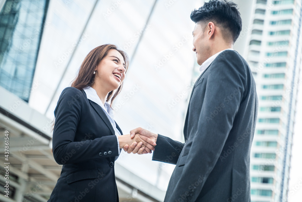Business people making handshake in city with skyscraper background. Business people making handshake in city with skyscraper background.