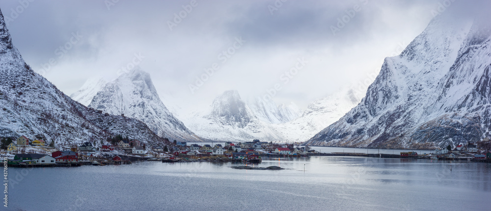 Winter landscape in north Norway: fjord with the little village of Reine against snow covered mountains