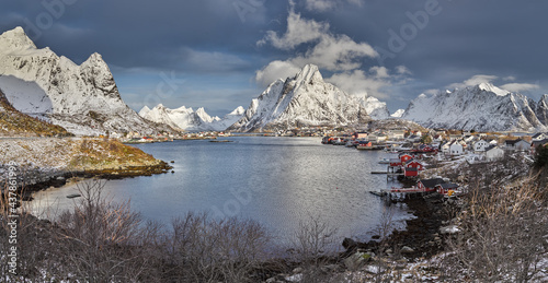 Winter landscape in north Norway: the fjord Gravdalsbukta, the fishing village of Reine and snow covered mountains photo