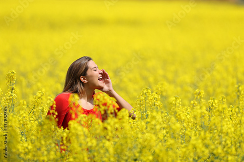 Woman in red screaming in a yellow field in spring season
