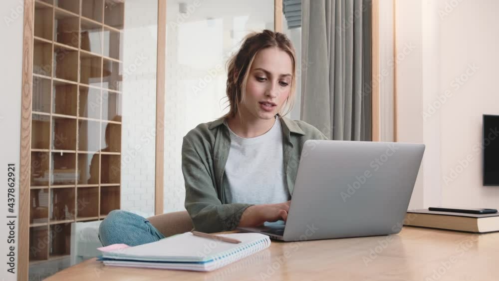 A good-looking blonde woman is using her laptop while sitting at home A good-looking blonde woman is using her laptop while sitting at home