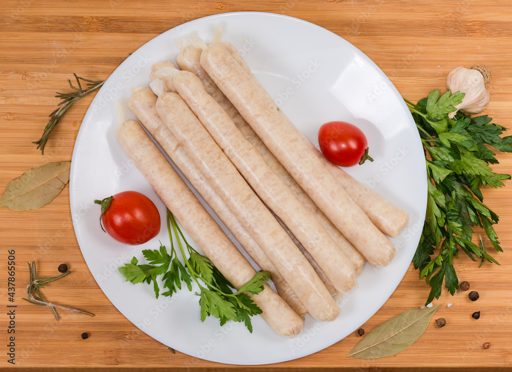 Top view of raw chicken sausages with spices on dish Top view of raw chicken sausages with spices on dish