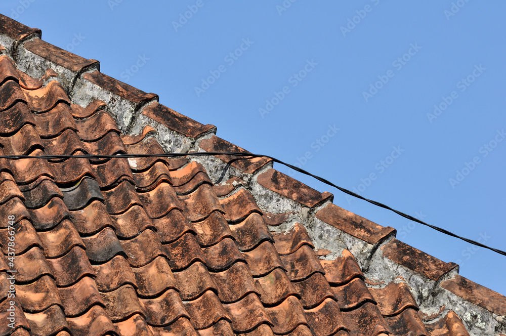 Traditional tile roof in a village in Indonesia with blue sky Traditional tile roof in a village in Indonesia with blue sky
