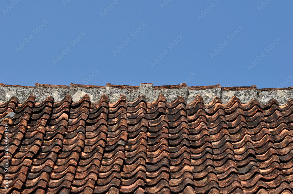 Traditional tile roof in a village in Indonesia with blue sky Traditional tile roof in a village in Indonesia with blue sky