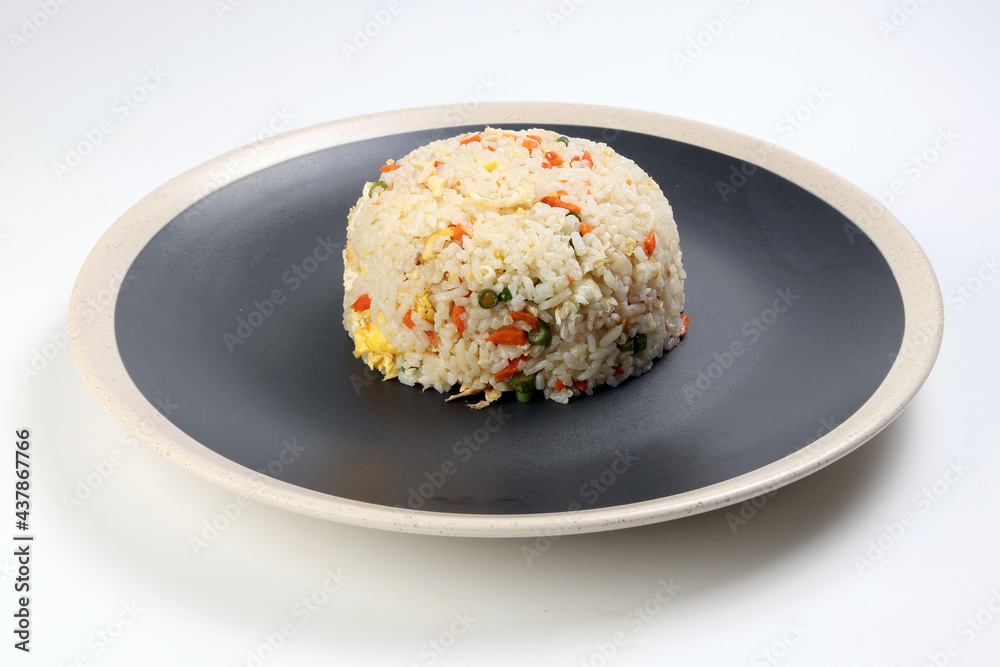 Chinese style egg fried rice with carrot green spring onion on black plate off white rim over white background