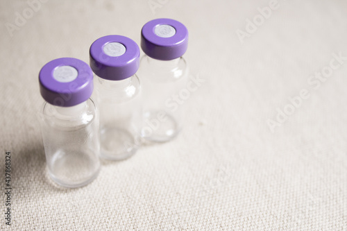 Empty glass jars of coronavirus vaccines