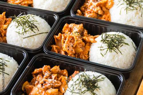 Korean food lunch boxes in plastic packages, Rice and spicy Korean pork stir-fry.