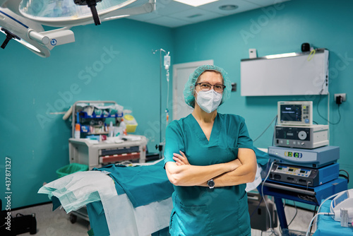Confident surgeon with crossed arms in operating room