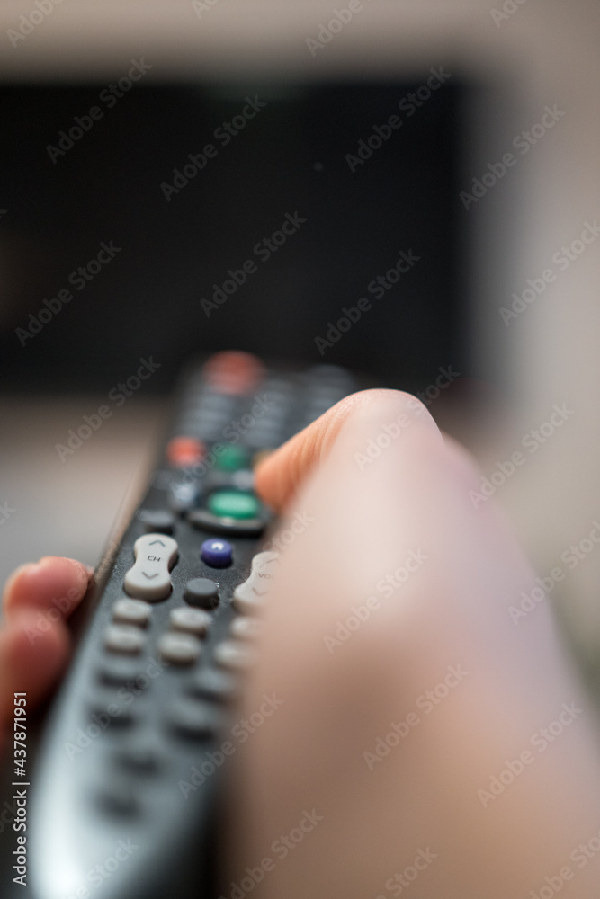 The TV remote buttons close-up. Entertainment on the couch. Switching TV programs The TV remote buttons close-up. Entertainment on the couch. Switching TV programs