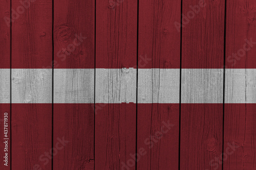 The National Flag of Latvia painted on a wooden wall. 
