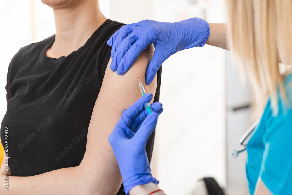 Vaccine and pandemics stills with people on a clinic environment. Covid-19 vaccination campaign concept with syringe applyed by doctor on a woman arm. Vaccine and pandemics stills with people on a clinic environment. Covid-19 vaccination campaign concept with syringe applyed by doctor on a woman arm.
