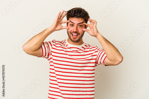 Young caucasian man isolated on white background keeping eyes opened to find a success opportunity.