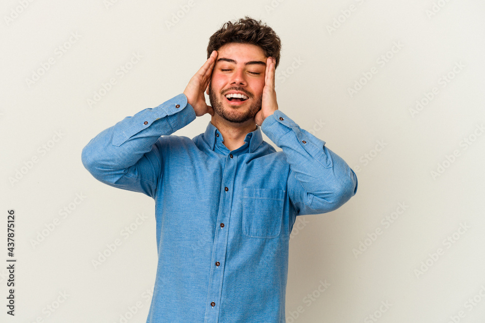 Young caucasian man isolated on white background laughs joyfully keeping hands on head. Happiness concept. Young caucasian man isolated on white background laughs joyfully keeping hands on head. Happiness concept.
