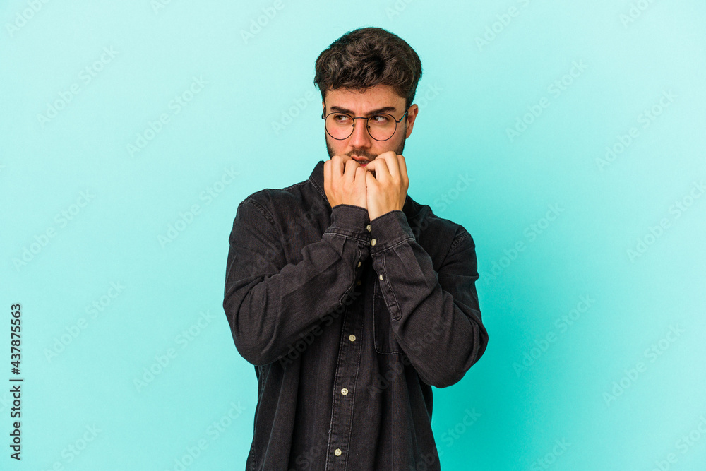 Young caucasian man isolated on blue background biting fingernails, nervous and very anxious. Young caucasian man isolated on blue background biting fingernails, nervous and very anxious.