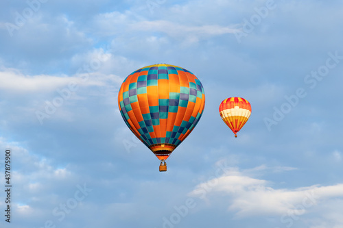 Balloon Festival Mongolfieria, A pair of multicolored, striped, bright balloons in the air against the blue sky.