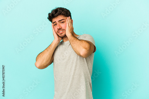 Obraz na płótnie Young caucasian man isolated on blue background whining and crying disconsolately