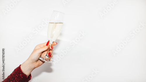 Birthday party. Festive drink. Happy celebration. Advertising background. Elegant female hand perfect red manicure holding champagne flute isolated white copy space.