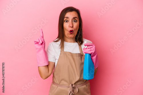 Middle age caucasian woman cleaning home isolated on pink background having some great idea, concept of creativity.