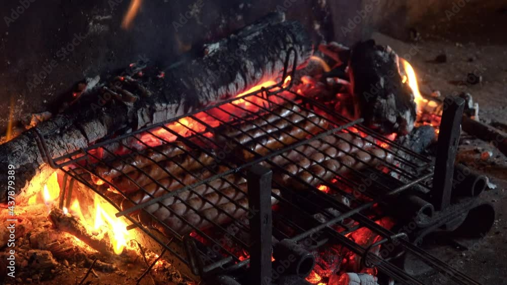 Sausages in grid of barbecue on the open air over the antique fireplace of a rustic stone house. Sausages in grid of barbecue on the open air over the antique fireplace of a rustic stone house.