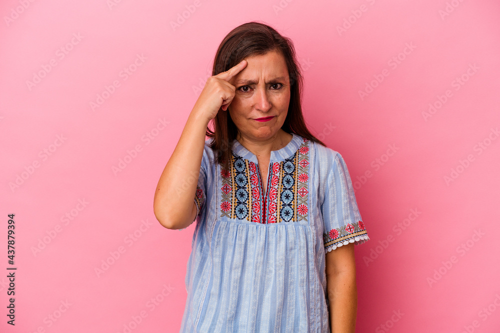 Middle age caucasian woman isolated on pink background pointing temple with finger, thinking, focused on a task. Middle age caucasian woman isolated on pink background pointing temple with finger, thinking, focused on a task.