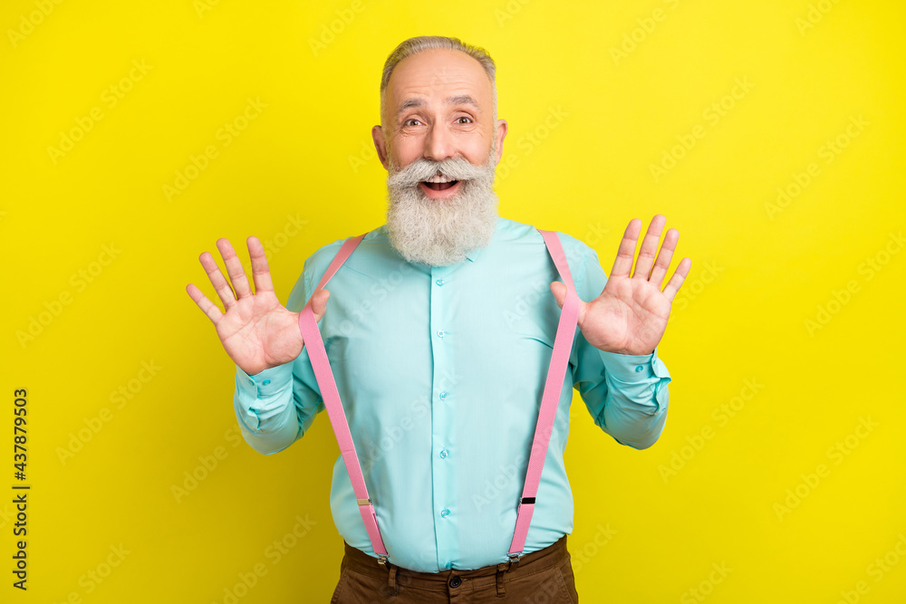 Photo of impressed beard mature man hands suspenders wear blue shirt isolated on vivid yellow color background Photo of impressed beard mature man hands suspenders wear blue shirt isolated on vivid yellow color background